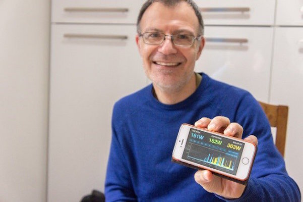 Dom McCann holding an energy monitor display